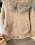 Beige jacket with fur hood on a wooden floor