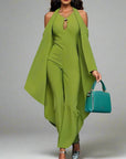 Woman in a green outfit holding a blue handbag on a blurred background