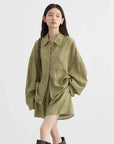 Woman wearing a green oversized shirt dress on a white background