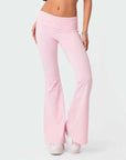 Person wearing light pink flared pants on a white background