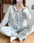 Person wearing a light blue floral pajama set sitting on a wooden floor.