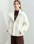 Woman wearing a white puffer jacket with a plain background, featuring the AMII brand.