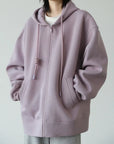 Person wearing a light purple hoodie on a plain background